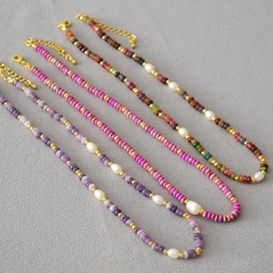 Detail of colorful gemstone necklaces with freshwater pearls and gold lobster clasps