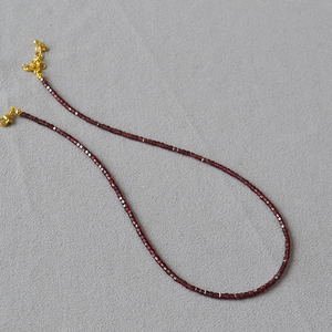 Nahaufnahme der tiefroten Naturstein-Perlenkette mit verstellbarem goldenem Verschluss