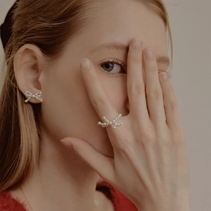 Elegante set di orecchini e anello con fiocco di perle su modella dal look raffinato