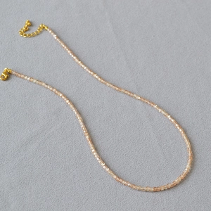 Detail of champagne crystal beaded necklace with golden lobster clasp and adjustable chain