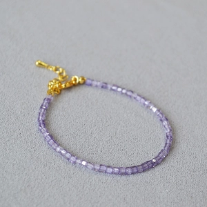 Elegant beaded bracelet featuring lavender cubic square stones with a gold-tone clasp
