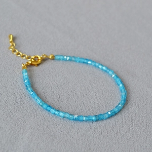 Macro shot of blue faceted crystal beads with a gold-plated adjustable lobster clasp