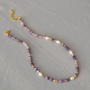 Detail of purple crystal beads and freshwater pearls with adjustable gold lobster clasp