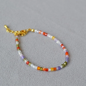 Detailed shot of multi-color square crystal beads and adjustable gold lobster clasp bracelet