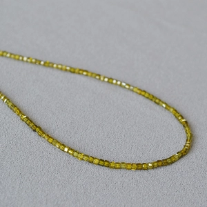Minimalist olive green square cut crystal beads necklace on a grey textured background