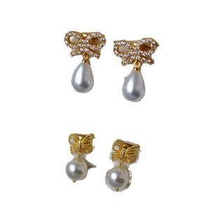 Bow and butterfly gold earrings set with sparkling zircons and drop-shaped white pearls
