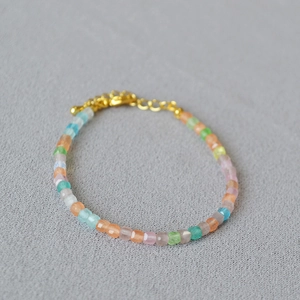 Detail of multi-color faceted sugar cube beads with a golden lobster clasp bracelet