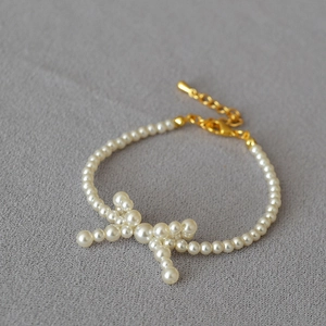 Elegant pearl choker necklace with a central pearl bow design and adjustable gold clasp