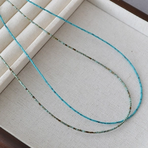 Gros plan d'un collier de perles turquoise fines avec des textures minérales naturelles