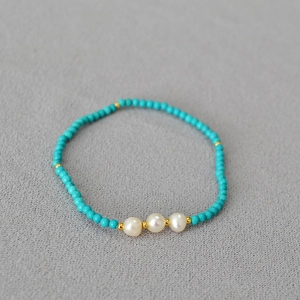 Détail du collier de perles turquoise avec perles d'eau douce et séparateurs dorés
