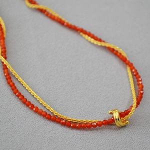 Double-layer gold chain necklace with red agate beads and a minimalist knot pendant