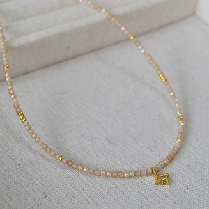 Détail du collier de perles en zircon champagne avec un pendentif en forme d'étoile dorée