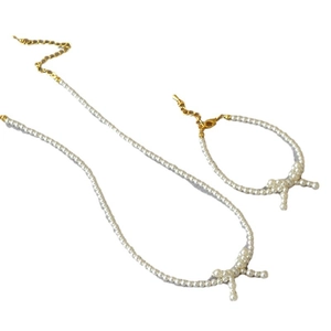Elegant pearl choker necklace and bracelet set with delicate pearl-woven bow and gold clasp