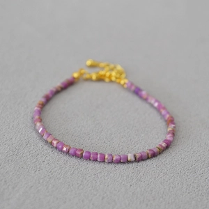 Vue macro d'un collier en perles d'apatite violette avec fermoir mousqueton doré