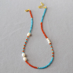 Détail du collier de perles d'eau douce avec perles rouges et accents d'apatite bleue