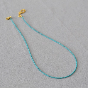 Détail du collier de perles turquoise avec fermoir mousqueton doré et chaîne d'extension