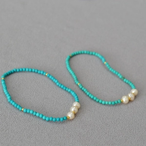 Détail de bracelets perlés avec pierres de turquoise bleues et perles baroques