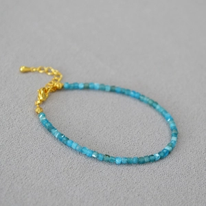Détail macro de perles d'apatite facettées avec fermoir mousqueton doré et extension