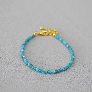 Détail macro du collier en perles d'apatite bleue avec fermoir mousqueton doré et chaîne