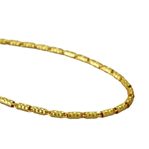 Collana a catena dorata con maglie cilindriche testurizzate su sfondo bianco pulito