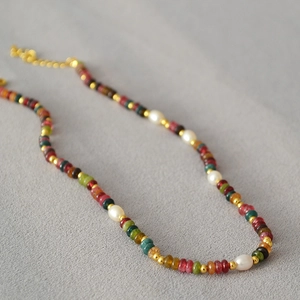 Detailed view of colorful natural stone beads with pearls and golden lobster clasp