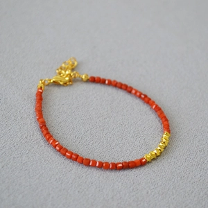 Macro detail of red agate square beads necklace with faceted gold spacers and lobster clasp
