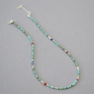 Macro detail of Bohemian beaded necklace with colorful turquoise beads and adjustable silver clasp