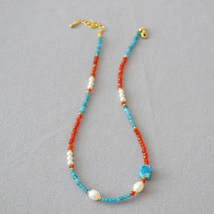 Detailed view of handmade beaded necklace with agate, apatite and white pearl stones