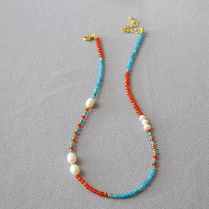 Collier Dunhuang avec agate, apatite et perles de riz d'eau douce sur fond de tissu gris