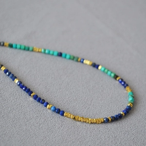 Detail of lapis lazuli and turquoise beaded necklace with small silver accents