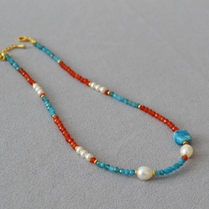 Detail of beaded necklace with apatite, carnelian, and pearls featuring gold clasp
