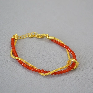 Macro detail of double-layer gold mesh chain and red agate beads with lobster clasp
