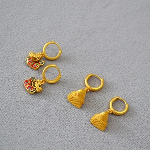 Detailed close-up of brass dragon boat and zongzi earrings with colorful enamel coating