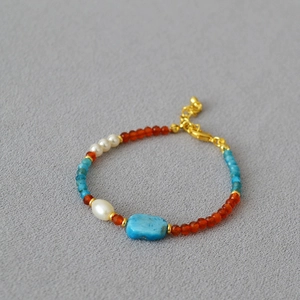 Retro handmade beaded necklace with agate and apatite on a textured grey background