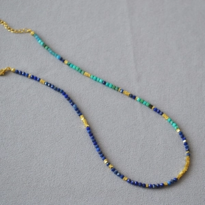 Detailed shot of beaded necklace with lapis lazuli, turquoise, and gold spacer beads