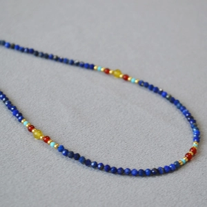 Close-up of lapis lazuli and agate beaded necklace with colorful faceted stone details