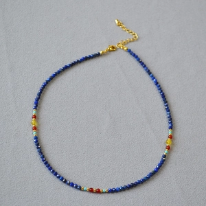 Macro shot of lapis lazuli beaded necklace with turquoise and red agate stone details