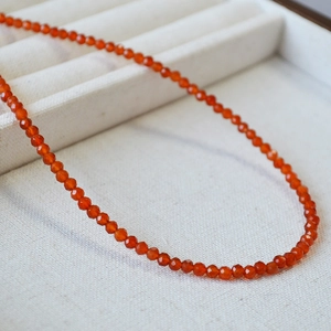 Elegant red faceted agate beaded necklace displayed in a premium cream jewelry box