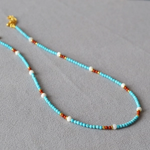 Macro view of turquoise beaded necklace with gold spacers and vintage shell details