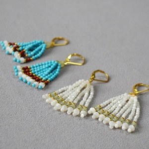 Détail de boucles d'oreilles faites à la main avec perles turquoise et fermoirs dorés