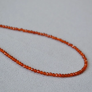 Macro view of faceted red agate beads showing translucent texture and fine craftsmanship