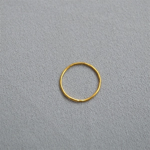 Elegant gold minimalist ring with hand-hammered texture on gray velvet background