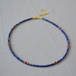 Detailed shot of lapis lazuli beads with red agate accents and golden lobster clasp