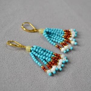 Vue détaillée de boucles d'oreilles à pompons en perles de turquoise faites à la main