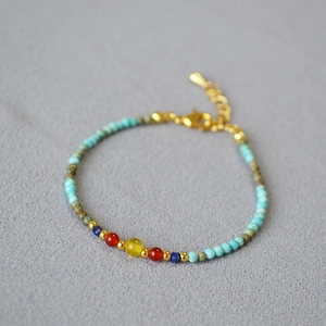 Close-up of handmade necklace with green turquoise beads and a yellow center stone