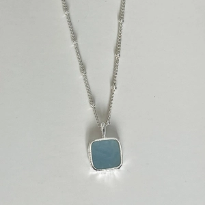 Detail of silver square aquamarine pendant with minimalist satellite bead chain necklace
