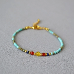 Close-up of turquoise beads with colorful accents and gold lobster clasp jewelry