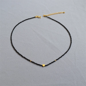 Collier minimaliste en perles noires avec un pendentif cœur doré et fermoir ajustable