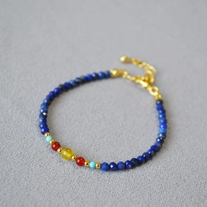 Close-up of lapis and agate beaded necklace with gold spacers and lobster clasp