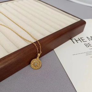 Elegante goldene Blumenhalskette mit Mondstein-Rundanhänger auf Schmuckpräsentation